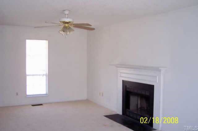 3609 Christine Court Raleigh, NC 27604 - Photo 4 of 12 an empty room with a fireplace and fan