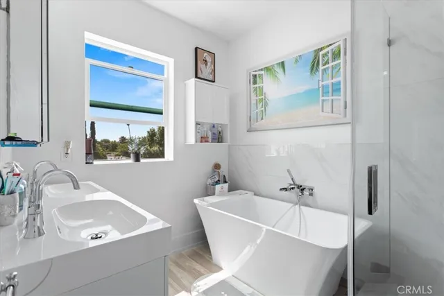 a bathroom with a tub a sink and a window