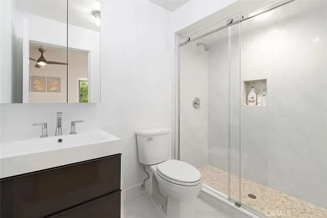 a bathroom with a sink a toilet and shower