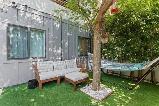 a view of a chair and table in backyard of the house