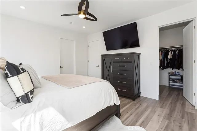 a bedroom with a bed and a flat tv screen on wall