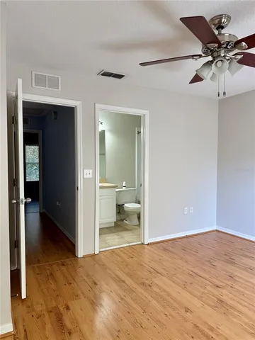 a view of a room with wooden floor and ceiling fan