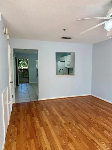 a view of a room with wooden floor and a bathroom