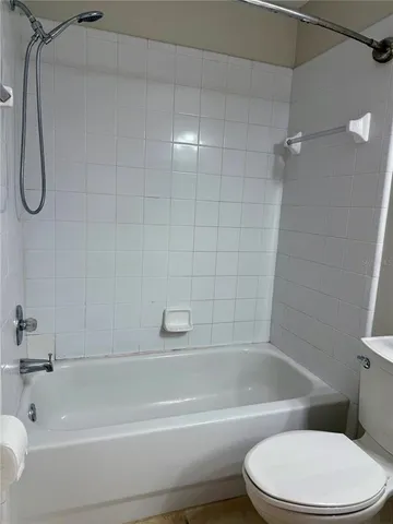 a bathroom with a toilet and a bath tub