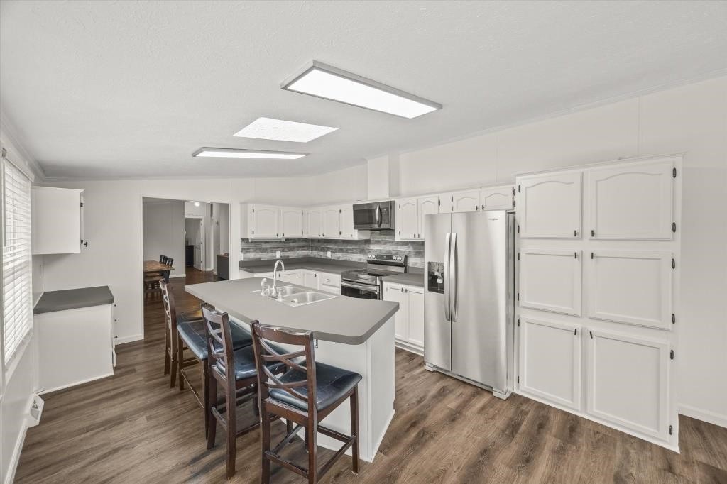 938 Riley Creek Road Whitleyville, TN 38588 - Photo 11 of 40 a kitchen with stainless steel appliances a refrigerator a stove a dining table and chairs with wooden floor