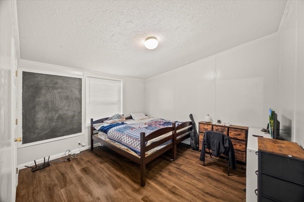 938 Riley Creek Road Whitleyville, TN 38588 - Photo 17 of 40 a bedroom with a bed and wooden floor