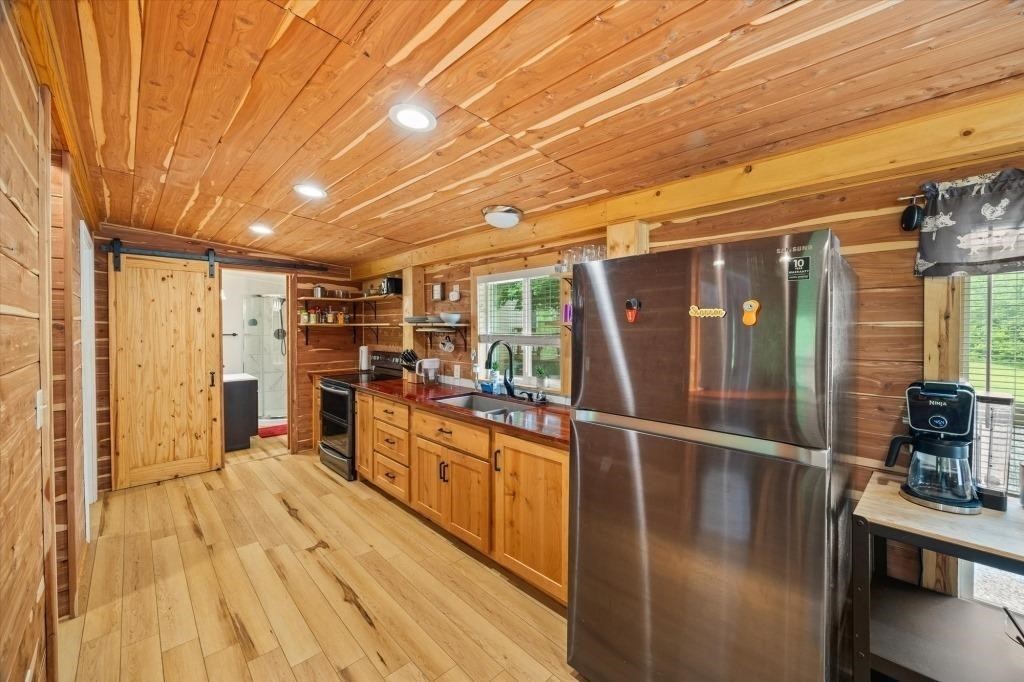 938 Riley Creek Road Whitleyville, TN 38588 - Photo 29 of 40 a open kitchen with stainless steel appliances granite countertop a stove and cabinets with wooden floor