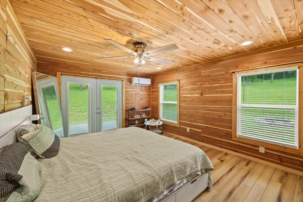 938 Riley Creek Road Whitleyville, TN 38588 - Photo 31 of 40 a bedroom with a large bed and large windows