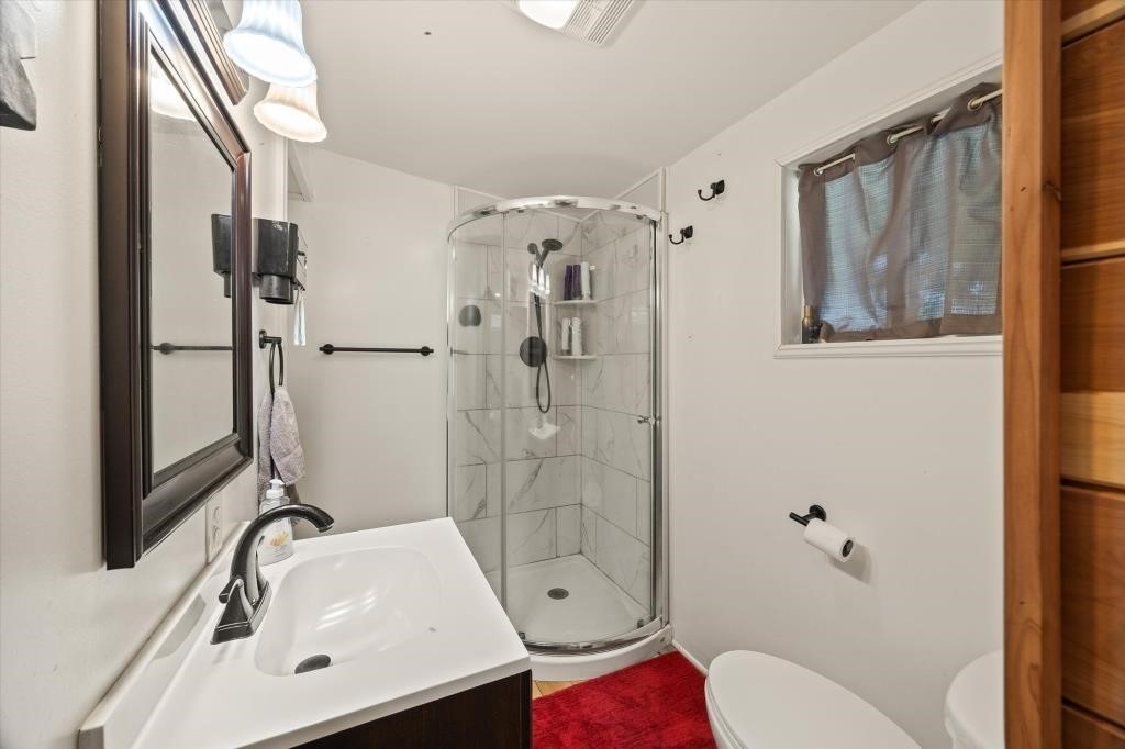 938 Riley Creek Road Whitleyville, TN 38588 - Photo 33 of 40 a bathroom with a granite countertop sink toilet and shower