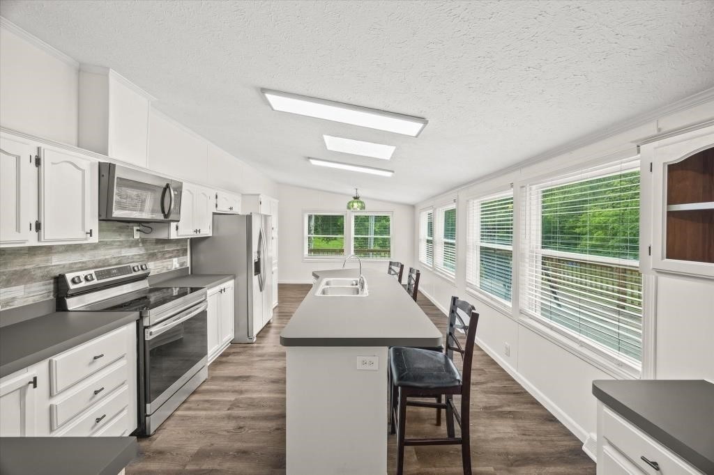 938 Riley Creek Road Whitleyville, TN 38588 - Photo 9 of 40 a kitchen with stainless steel appliances granite countertop a stove top oven a sink and dishwasher