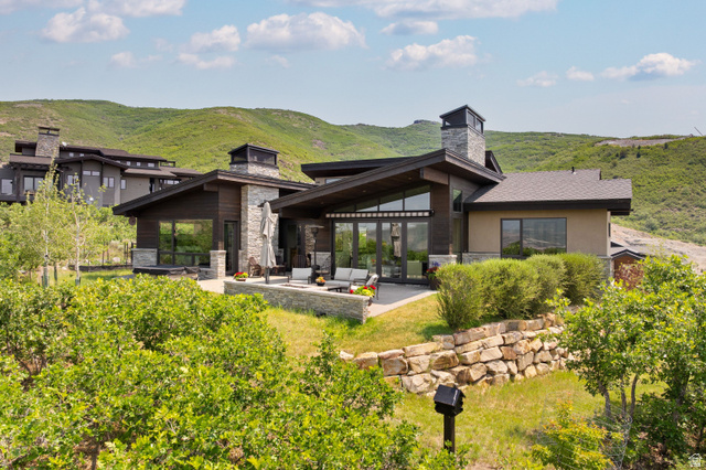 11547 Soaring Hawk Lane Hideout, UT 84036 - Photo 40 of 43 Contemporary exterior with stone and wood-finish siding, featuring a spacious patio area