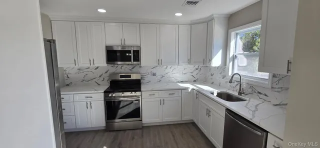 a kitchen with cabinets stainless steel appliances and a sink