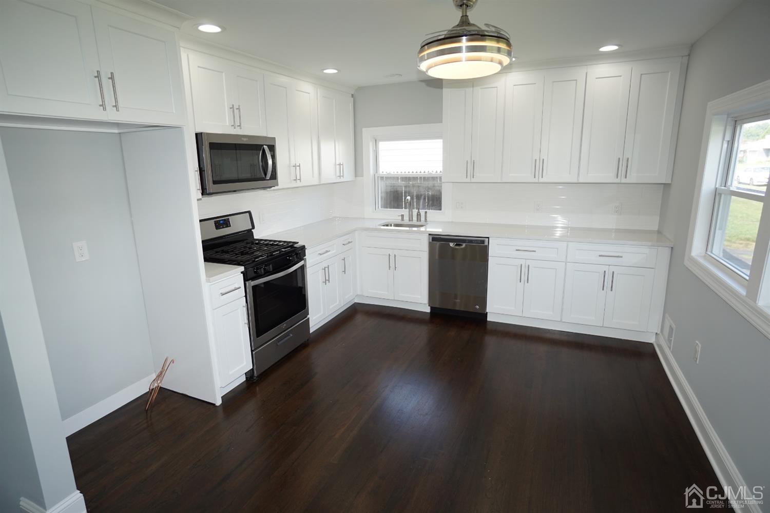 69 Albemarle Road Colonia, NJ 07067 - Photo 9 of 40 a kitchen with a stove a sink and a microwave