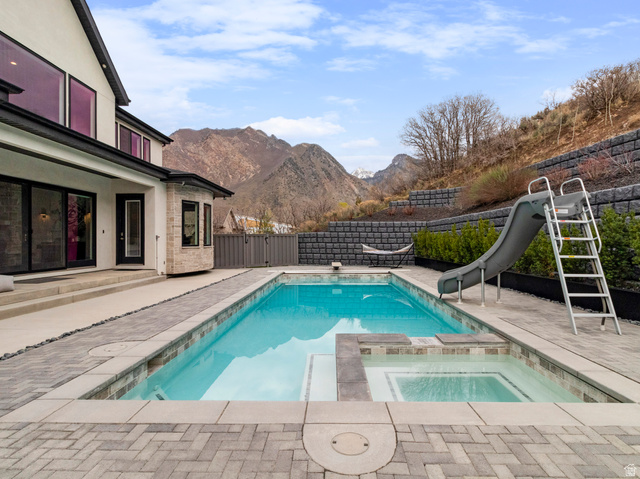 614 East High Lane Alpine, UT 84004 - Photo 8 of 75 Relaxing pool / spa featuring a patio area, a fenced backyard, a water slide, and a mountain view
