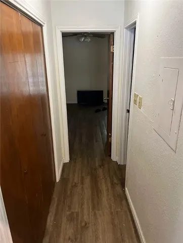 a view of a hallway with wooden floor and staircase