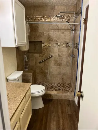a bathroom with a granite countertop toilet and a sink