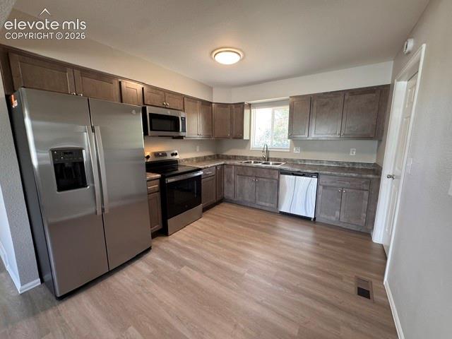 1922 Monterey Road Colorado Springs, CO 80910 - Photo 7 of 21 a kitchen with stainless steel appliances granite countertop a refrigerator a sink a stove a microwave and wooden floors