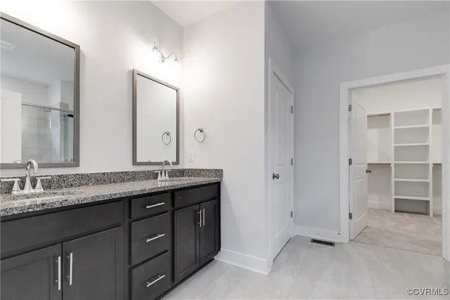 a bathroom with a granite countertop sink double and mirror