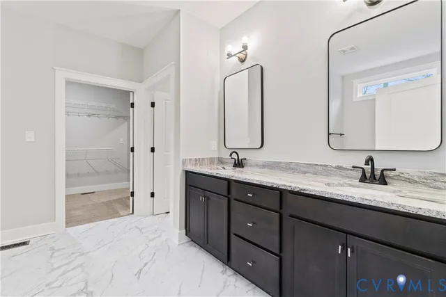 a bathroom with double vanity sinks and a shower