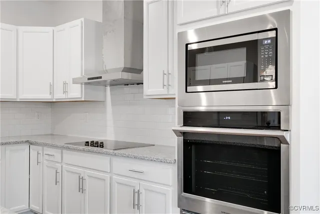 a kitchen with stainless steel appliances granite countertop white cabinets and stove