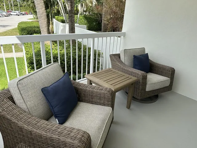a balcony view with a couch and table and chairs