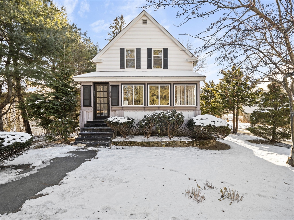 a front view of a house with a yard covered with snow