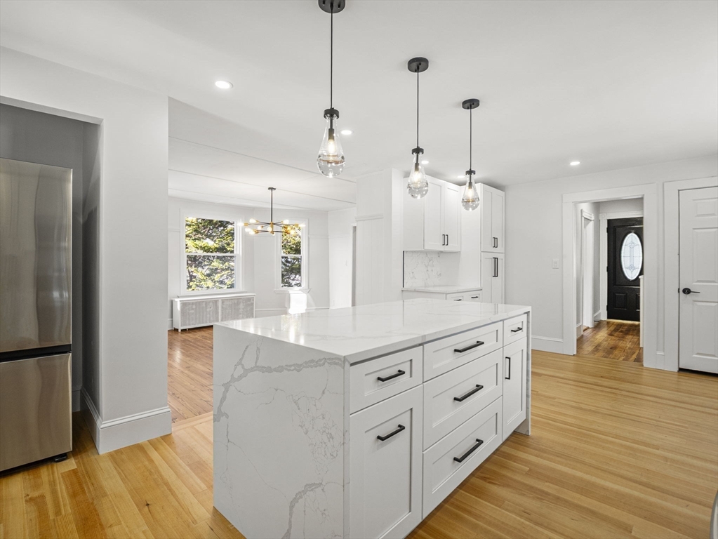 224 Pelham Street Methuen, MA 01844 - Photo 12 of 40 a kitchen with stainless steel appliances kitchen island granite countertop a refrigerator a sink dishwasher and a wooden floor
