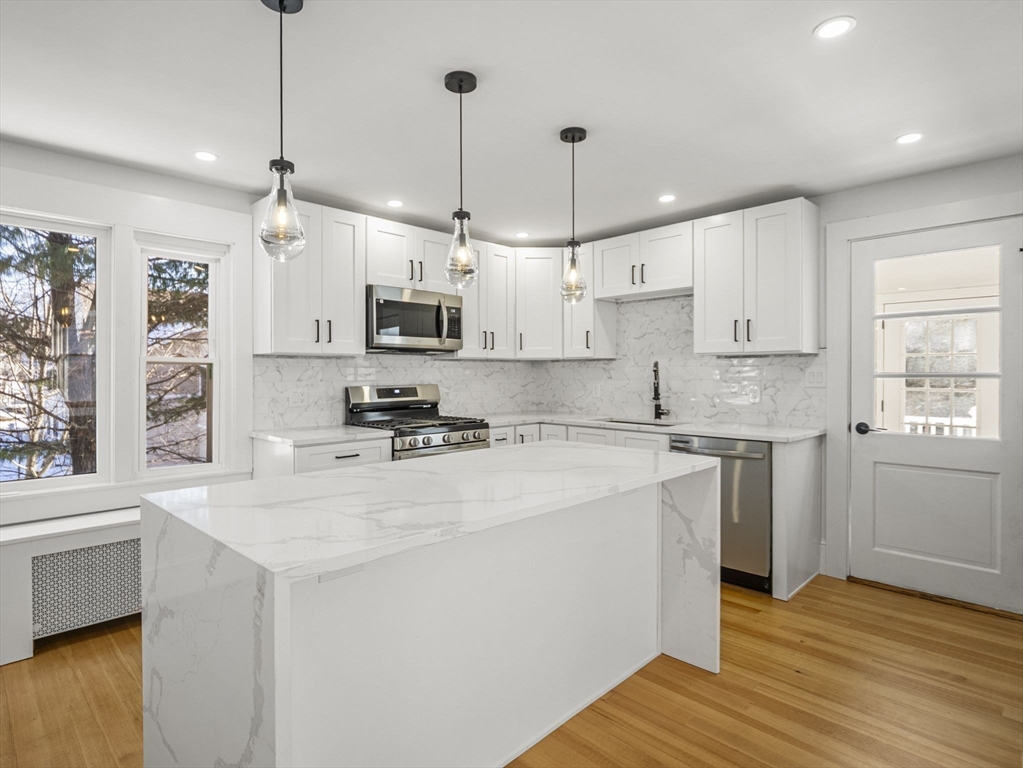 224 Pelham Street Methuen, MA 01844 - Photo 7 of 40 a kitchen with stainless steel appliances granite countertop a sink a stove a refrigerator and white cabinets with wooden floor