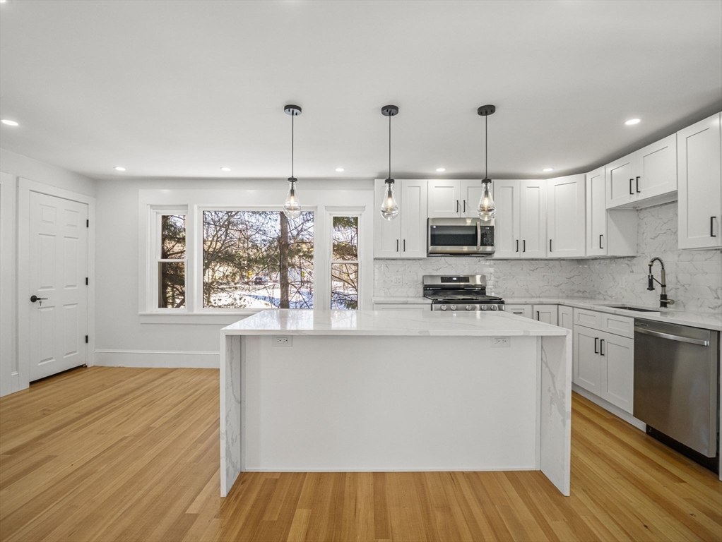 224 Pelham Street Methuen, MA 01844 - Photo 8 of 40 a kitchen with stainless steel appliances granite countertop a sink a stove and a wooden floors
