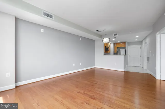 a view of a big room with wooden floor and windows