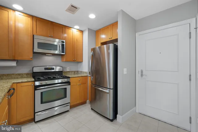 a kitchen with stainless steel appliances granite countertop a refrigerator stove and sink