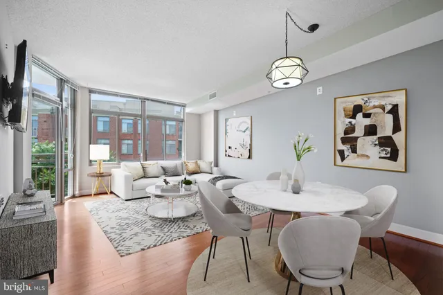 a dining room with wooden floor a chandelier a wooden table and chairs