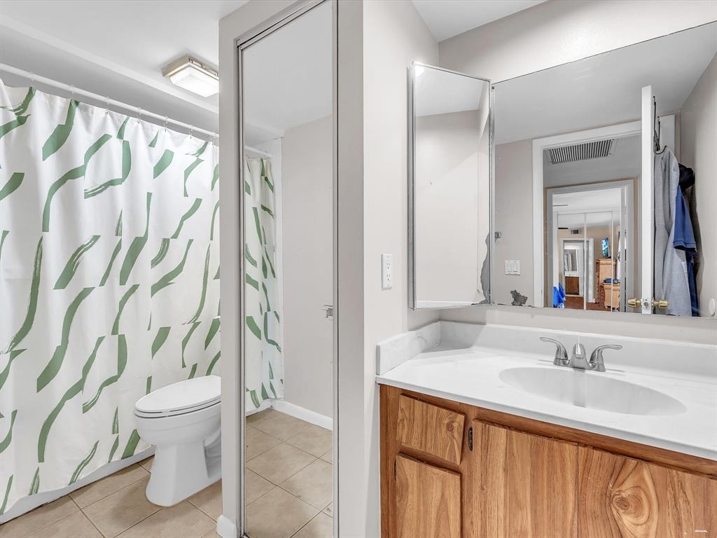 2947 Southwest 22nd Circle, Unit 28D Delray Beach, FL 33445 - Photo 20 of 32 a bathroom with a sink a toilet and a mirror