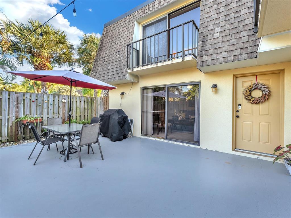 2947 Southwest 22nd Circle, Unit 28D Delray Beach, FL 33445 - Photo 23 of 32 a view of a patio with a table and chairs under an umbrella