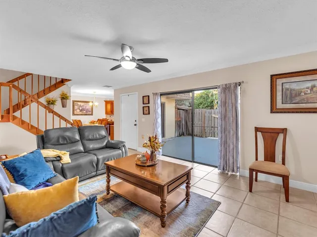 a living room with furniture a ceiling fan and a window