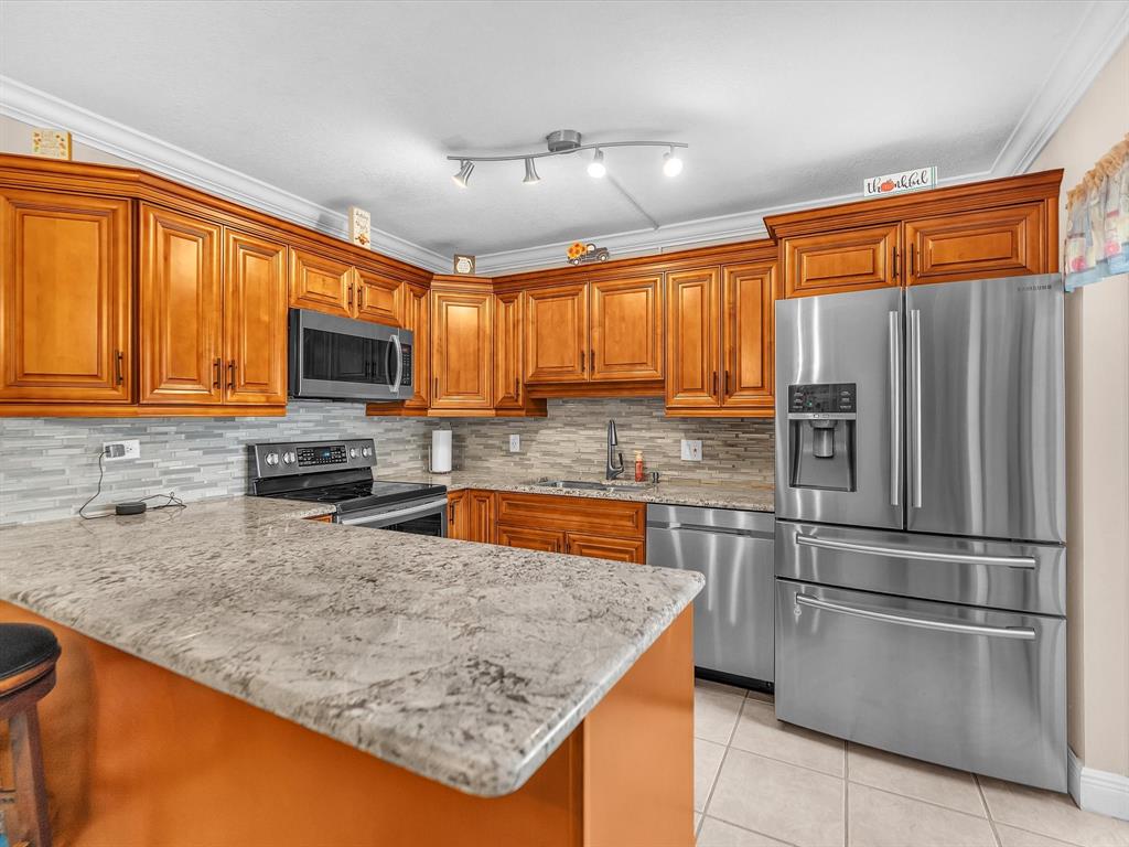 2947 Southwest 22nd Circle, Unit 28D Delray Beach, FL 33445 - Photo 6 of 32 a kitchen with stainless steel appliances granite countertop a refrigerator stove top oven a sink and dishwasher