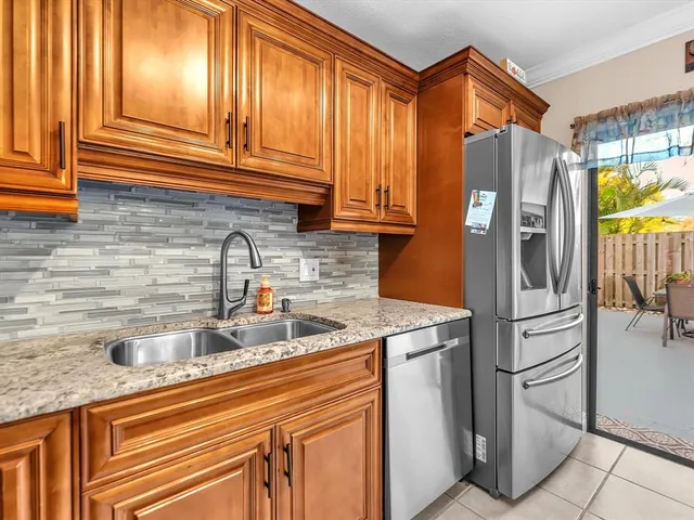 a kitchen with stainless steel appliances granite countertop a refrigerator and a sink