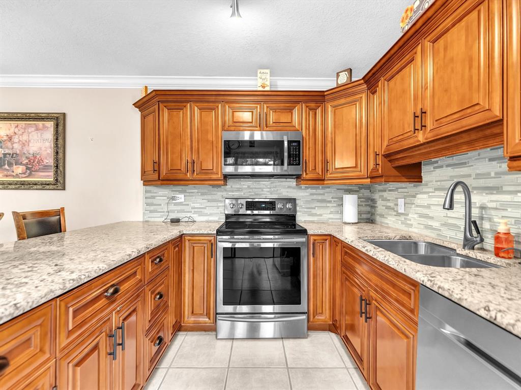 2947 Southwest 22nd Circle, Unit 28D Delray Beach, FL 33445 - Photo 8 of 32 a kitchen with granite countertop a sink and cabinets