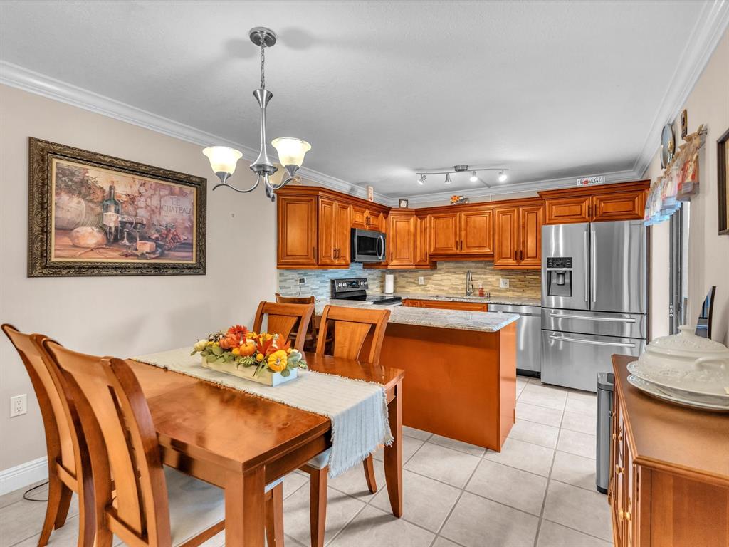 2947 Southwest 22nd Circle, Unit 28D Delray Beach, FL 33445 - Photo 10 of 32 a dining room dining table chairs and kitchen view