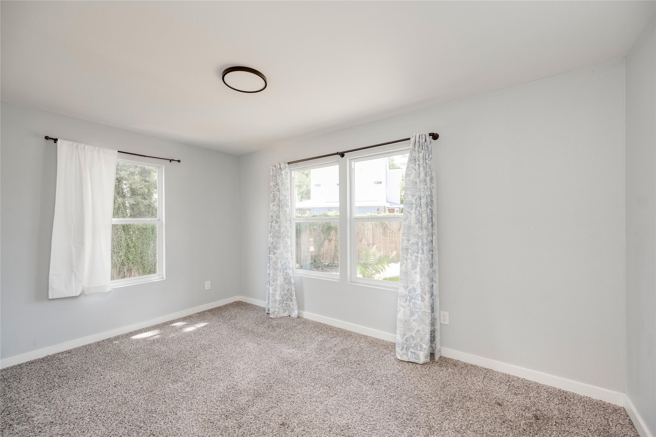 1400 Marcus Place, Unit B Austin, TX 78721 - Photo 12 of 39 A well-lit bedroom offering a neutral palette, plush carpeting, and generous natural illumination from multiple windows.