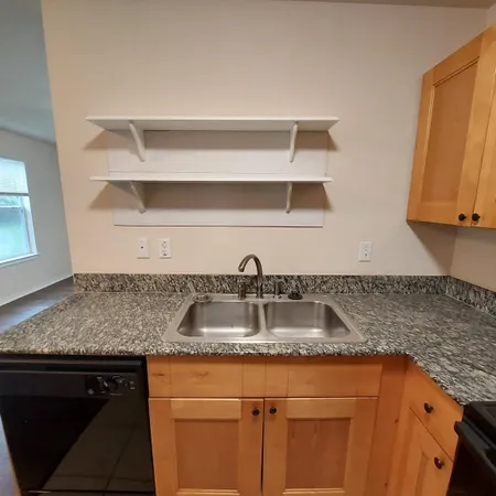 a kitchen with granite countertop a sink and cabinets