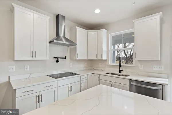 a kitchen with white cabinets appliances and sink