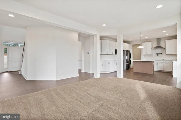 a view of a kitchen with refrigerator and white cabinets