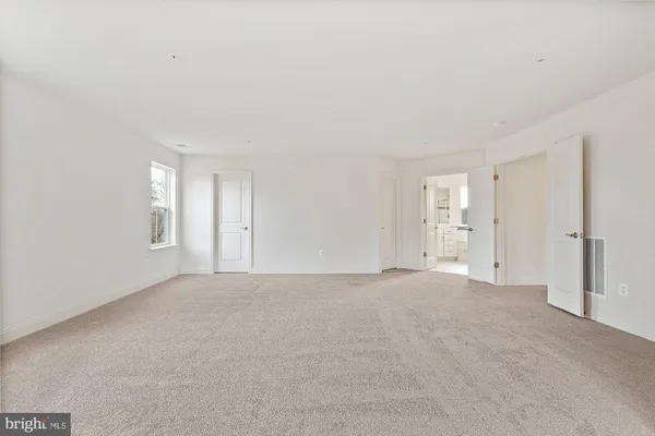 a view of an empty room with window and closet area