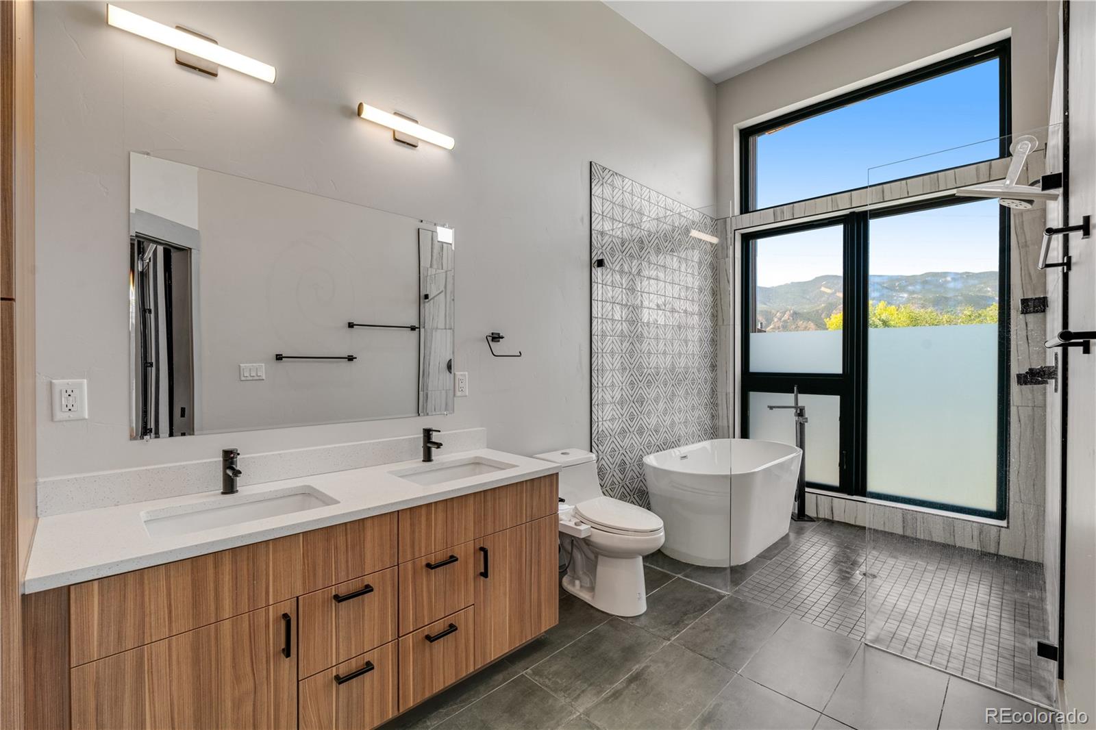 2260 Glenn Street Colorado Springs, CO 80904 - Photo 22 of 45 a bathroom with a double vanity sink a toilet and a shower
