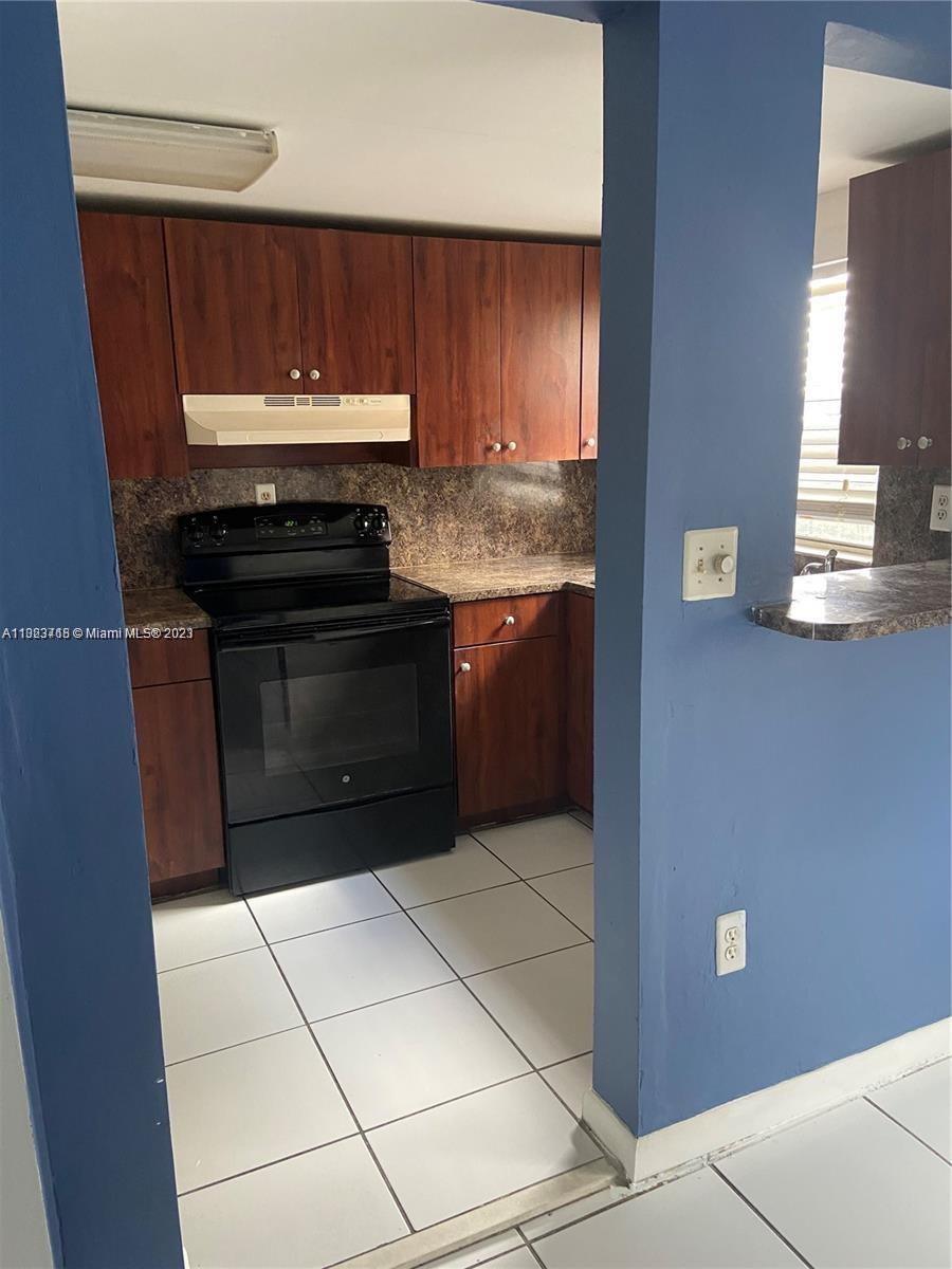 2743 Southwest 32nd Avenue Miami, FL 33133 - Photo 27 of 33 a kitchen with granite countertop a stove top oven and cabinets