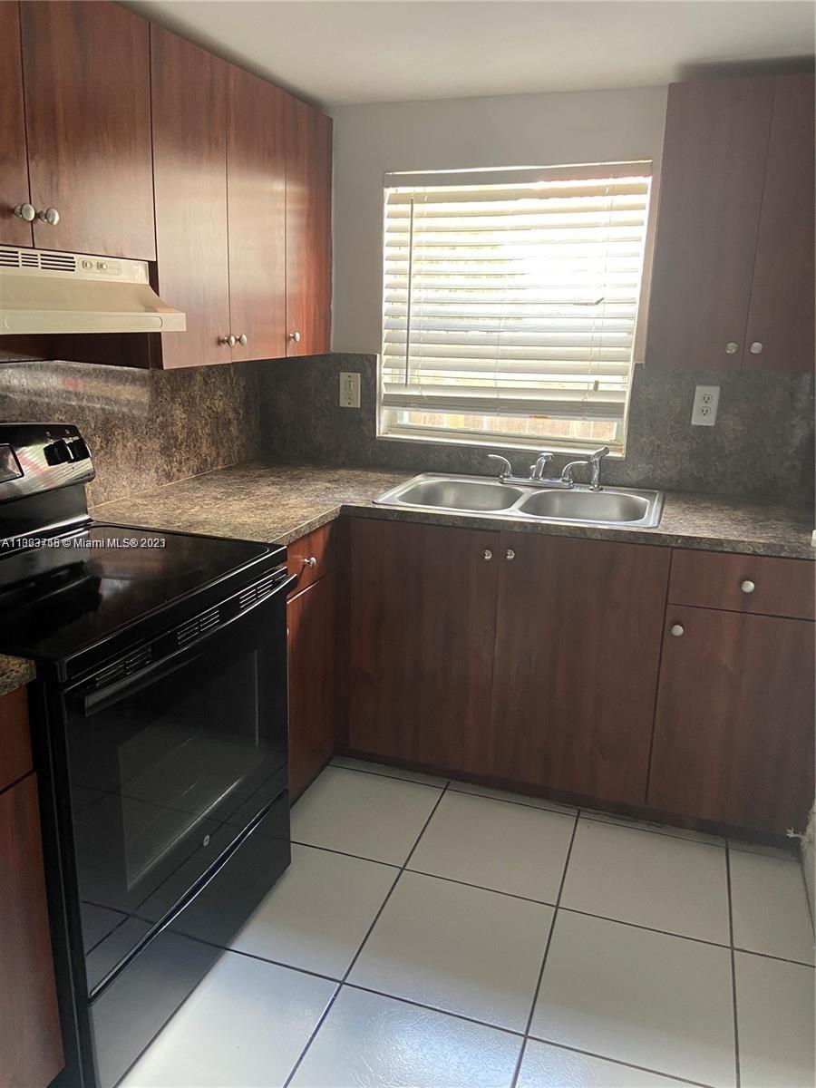 2743 Southwest 32nd Avenue Miami, FL 33133 - Photo 32 of 33 a kitchen with granite countertop a stove a sink and a cabinets