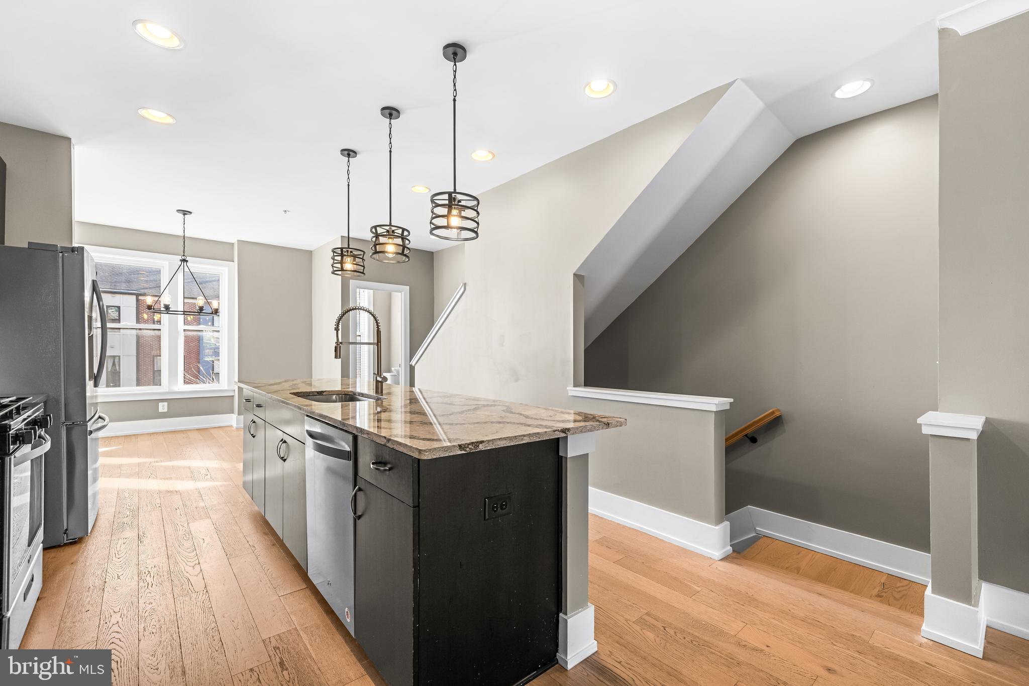 1456 Redfern Avenue Baltimore, MD 21211 - Photo 18 of 44 a kitchen with stainless steel appliances granite countertop a sink a stove and a wooden floor