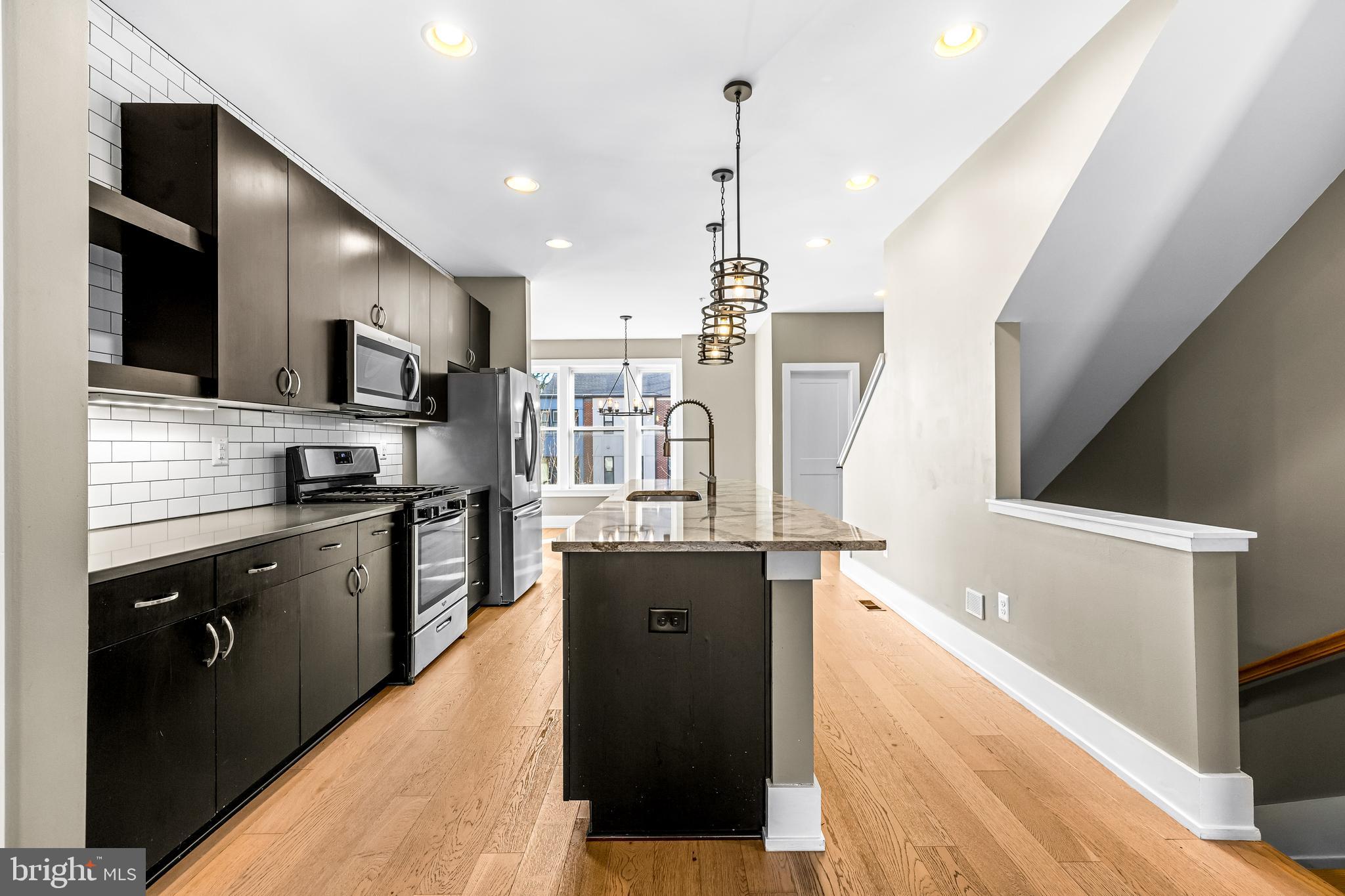 1456 Redfern Avenue Baltimore, MD 21211 - Photo 19 of 44 a kitchen with stainless steel appliances granite countertop a refrigerator a sink and a stove