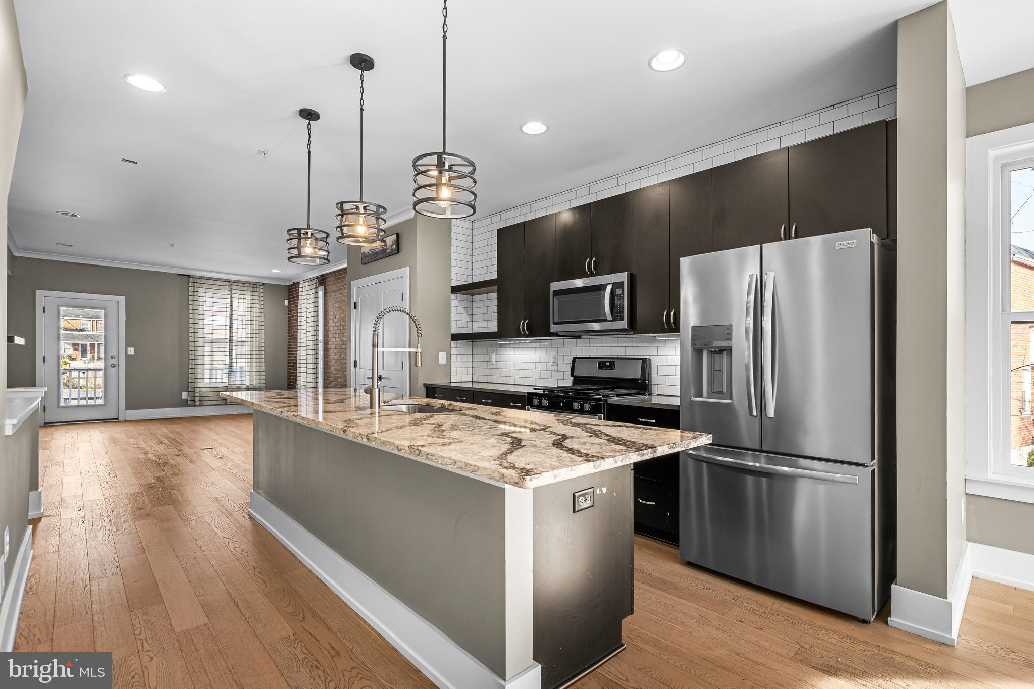1456 Redfern Avenue Baltimore, MD 21211 - Photo 20 of 44 a kitchen with stainless steel appliances granite countertop a refrigerator a sink dishwasher a kitchen island a stove and a wooden floors